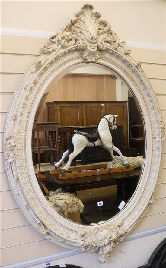 A large painted oval mirror, H.150cm